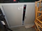 une petite armoire avec une porte et une chaise devant