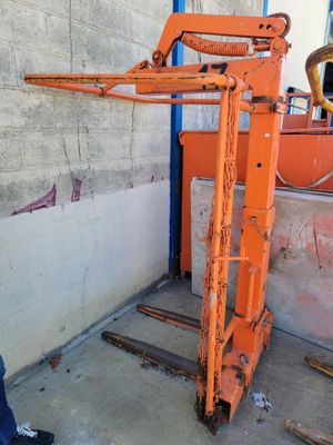 a man that is standing next to a forklift