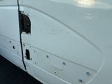 a close up of a white van door with holes in it