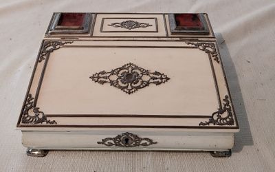 une boîte argentée et blanche posée sur une nappe blanche