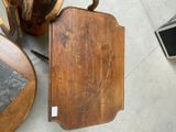a wooden cutting board sitting on the floor next to a chair