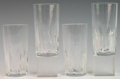quatre grands vases en verre posés sur une surface blanche