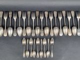 a close up of a bunch of spoons and forks on a table