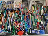 beaucoup de stylos et de crayons qui se trouvent dans une valise