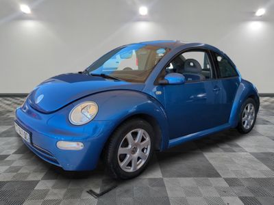 a picture of a blue volkswagen beetle parked in a garage