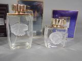 two bottles of perfume sitting next to each other on a table