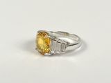 an image of a yellow sapphire and diamond ring on a white surface