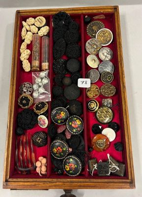 une boîte en bois remplie d'un assortiment de boutons et de bijoux