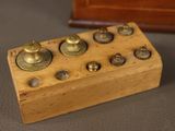 a small wooden box with brass knobs on it