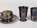 three cups and a saucer sitting on a table