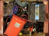 une boîte remplie de matériel électrique divers, posée par terre