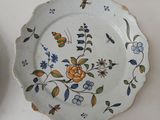 a plate with a floral design on it next to a cup