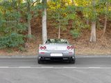 a car that is driving down the street in front of some trees