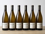 six bouteilles de vin blanc alignées sur une table en bois