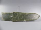 a picture of a green stone knife on a white surface
