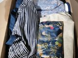 une boîte remplie de vêtements, avec un sac à main à l'intérieur