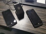 trois téléphones portables posés sur une table à côté d'un ordinateur portable
