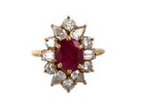 gros plan d'une bague avec une pierre rouge entourée de diamants blancs