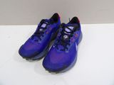 une paire de chaussures de course violettes et noires posées sur une surface blanche