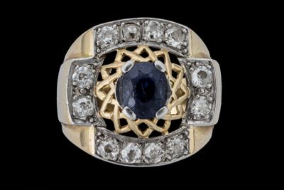 un gros plan d'une bague ornée d'un saphir bleu entouré de diamants