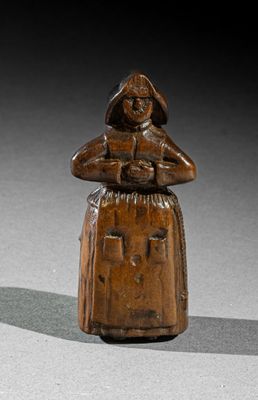 une vieille figurine en bois représentant une femme tenant un panier