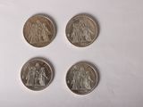 Quatre pièces de monnaie britanniques différentes sont représentées sur un fond blanc.