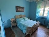 une chambre avec un lit, des murs bleus et un lustre