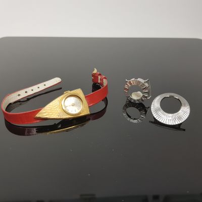 three different pieces of jewelry sitting on a table