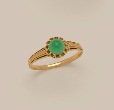 a gold ring with a green jade stone in the center