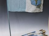 a small flag hanging on a wall next to a pair of arrows