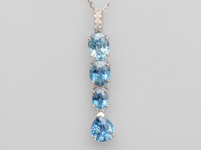 un pendentif en topaze bleue et diamants, monté sur une chaîne en argent