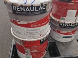 trois seaux de peinture posés sur une palette dans un entrepôt