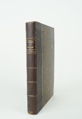 un vieux livre posé sur une table à côté d'un fond blanc