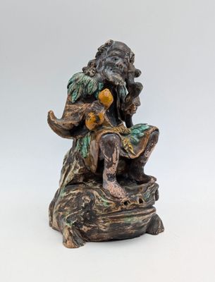une image représentant la statue d'un homme assis sur un rocher