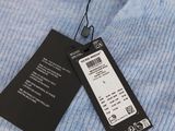 a close up of a blue sweater with a price tag on it
