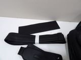 three pieces of black leather on a white table