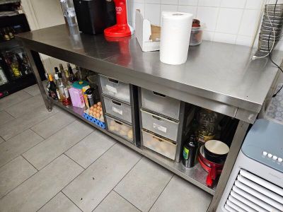 un comptoir en acier inoxydable sur lequel sont posés tout un tas d'objets