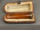 a small wooden case with a small pipe inside of it