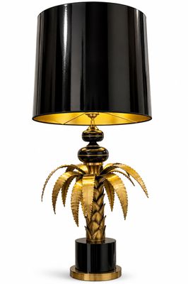 une lampe en forme de palmier, noire et dorée, avec un abat-jour noir