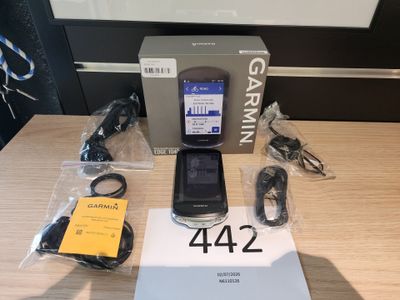 un appareil Garmin posé sur une table, à côté d'un chargeur