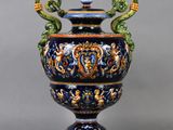 un vase bleu et vert muni de deux anses et posé sur un socle