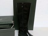 a pair of black boots that are next to a box