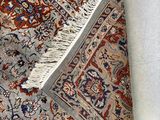 rug with fringes on top of it laying on a white surface
