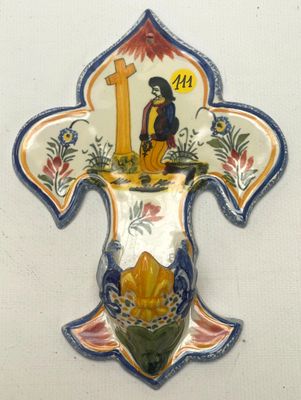 une tenture murale décorative sur laquelle figurent une croix et un oiseau