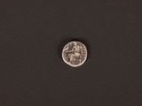 a silver coin on a black surface with a white background