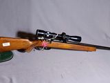 un gros plan d'un fusil posé sur une table, avec un chapeau à côté