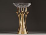 an image of a gold vase on a table with a black background