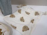 a teddy bear blanket on the counter next to a iron