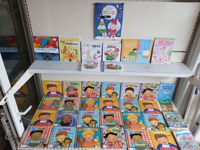 many children ' s books on the shelves in the room
