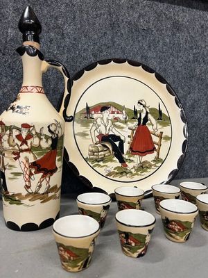 Des bouteilles et des tasses sont posées sur une table, à côté d'un vase.